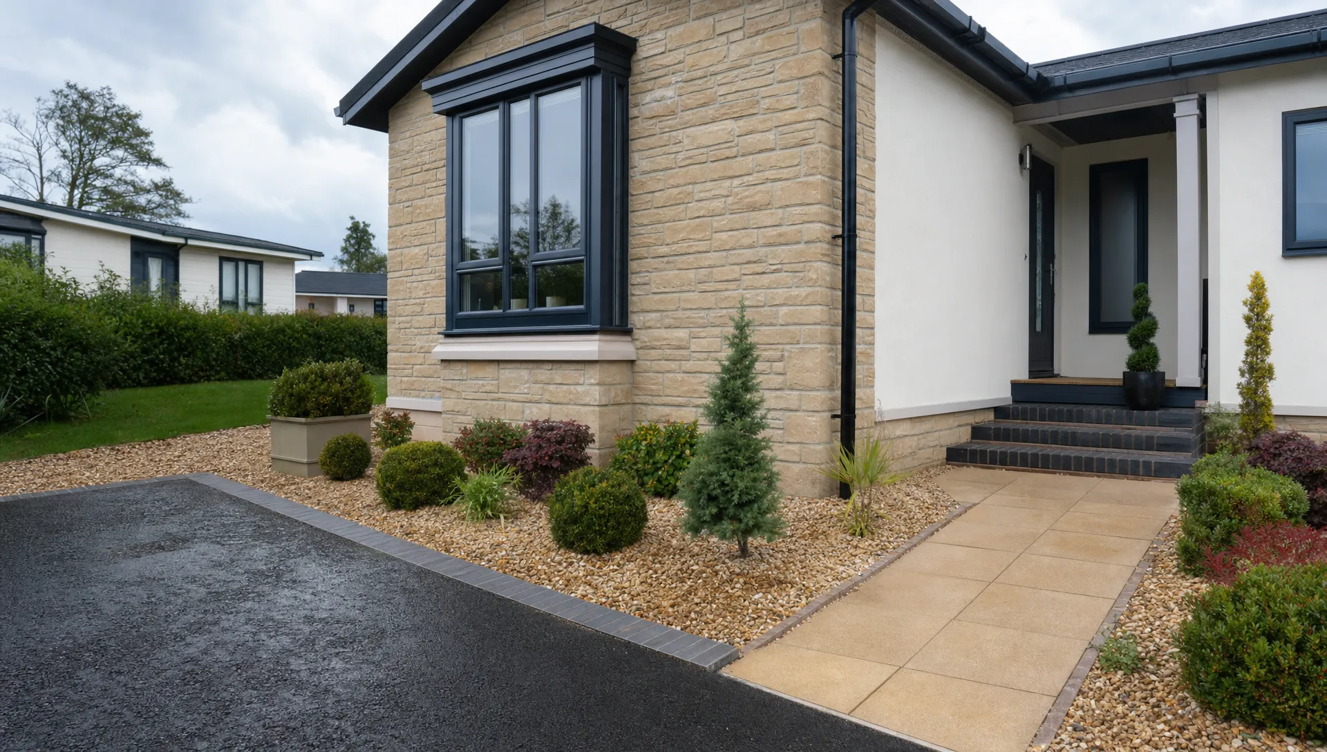 A close view of a Hermitage Park bungalow entrance with driveway edging, tidy planting and the single-storey facade.